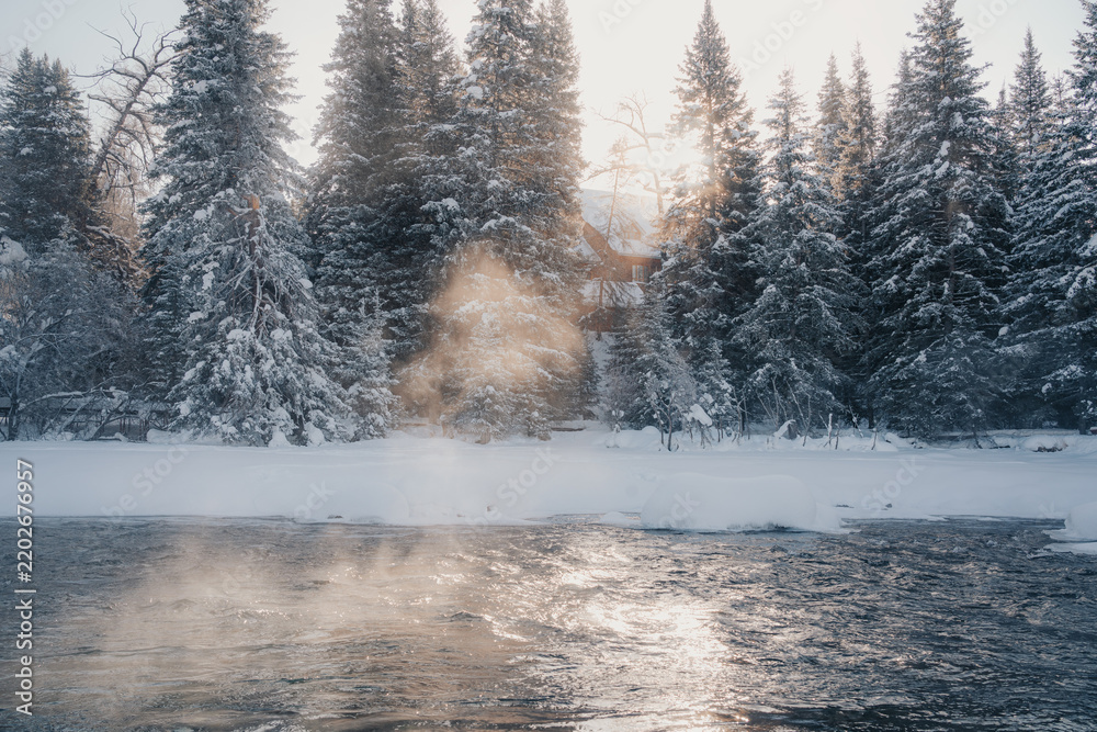 Obraz premium Sunbeams illuminating mist above the Kanas winter river