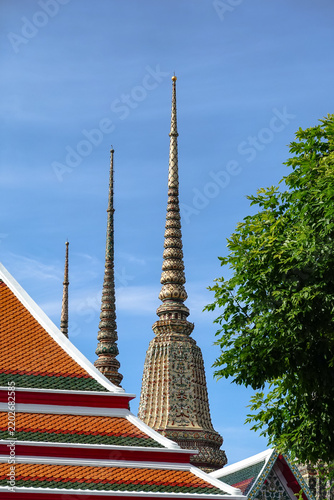A close-up view of a white stupa adorned with intricate gold Thai patterns at Wat Pho (Wat Phra Chetuphon Wimonmangkhalaram) in Bangkok, Thailand. This stupa is distinguished by its vibrant ceramic.