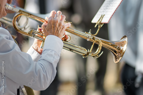 Close-up of musician playing trumpet with sheet music outdoors