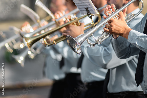 Close-up of musicians playing trumpets in uniformed band