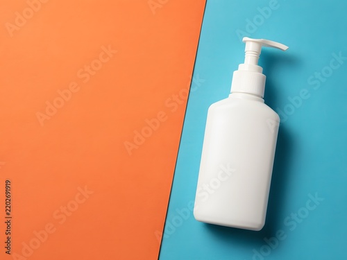 White plastic pump bottle on colorful split background for hygiene product display