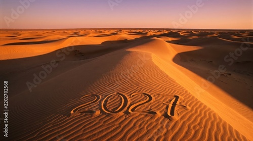 Year 2027 written in the sand of a vast desert landscape under warm golden hour sunlight