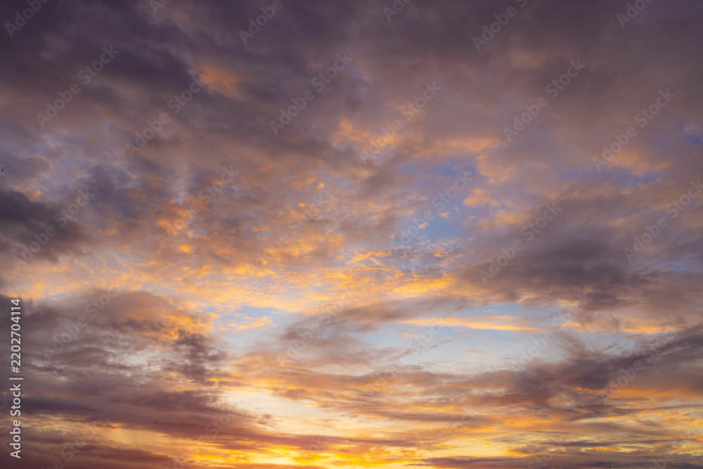 Fototapeta premium Panoramic Vibrant Sunset Sky with Colorful Twilight Clouds,A panoramic wide shot of a dramatic twilight sky filled with colorful clouds during sunset. The sky displays a vibrant gradient of bright