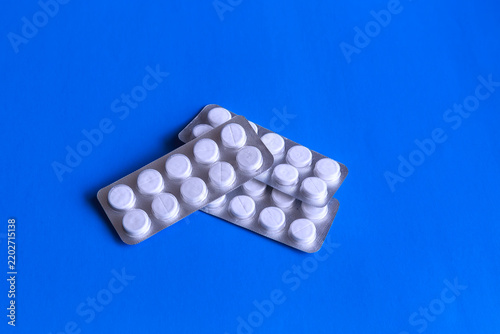 White Tablet Pills In Blister Packs On Blue Background For Medication And Healthcare