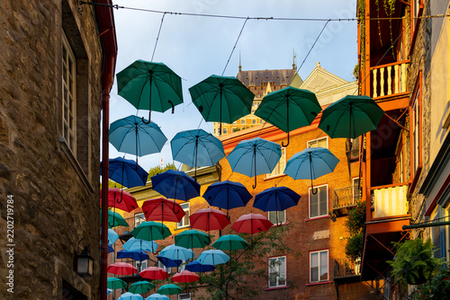 Decoration of colourful umbrellas over Patrimonial stone buildings on famous Cul-de-Sac street in the lower old town seen at dawn, Quebec City, Quebec, Canada