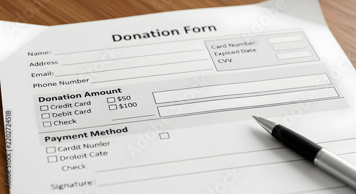 Donation form on a wooden table with a pen beside it for charitable contributions
