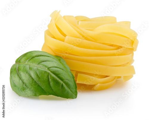 Raw tagliatelle pasta nest with fresh green basil leaf isolated on white background