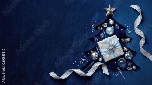 Elegant Christmas tree silhouette with silver ornaments and gift box on deep blue velvet background
