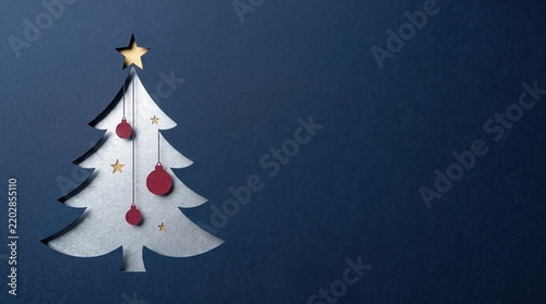 White paper Christmas tree decoration with baubles against a deep blue background