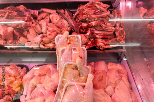 Raw chicken and beef displayed in refrigerated case