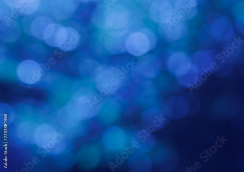 Dreamy blue bokeh creates an abstract background of soft glowing circles, layered light and rich cobalt tones with gentle turquoise accents and atmospheric depth.
