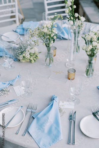 Elegant wedding dinner table with blue napkins and white flowers