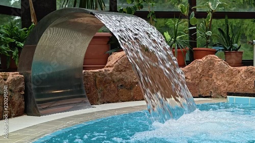 A pool with a waterfall, perfect for relaxation or a serene atmosphere