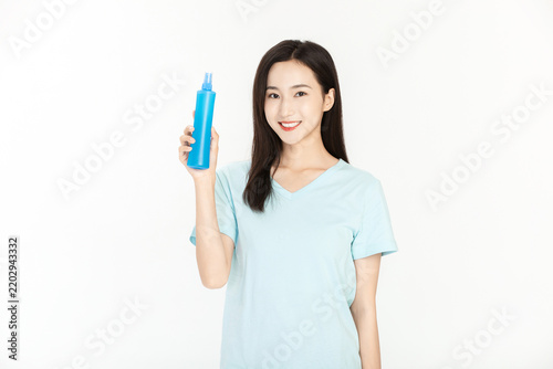 Smiling Asian Woman Holding Blue Mosquito Repellent Spray Bottle in Summer