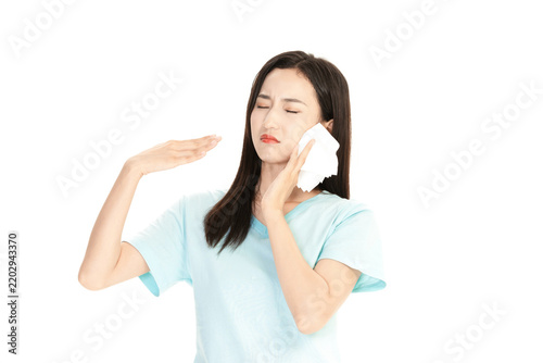 Young woman wiping sweat from her face with a tissue feeling hot and exhausted