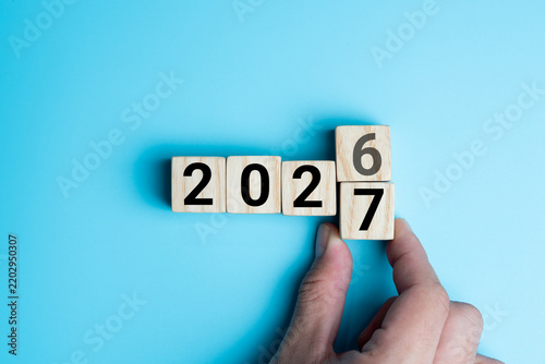 Foto Hand changing wooden block from 2026 to 2027 concept for new year planning and b