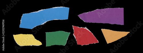 Set of six multicolored torn paper fragments in blue, purple, yellow, green, red and orange, with irregular curved shapes, rough ripped edges and spaced arrangement on black background