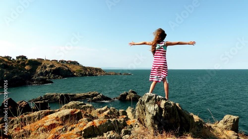 Little beautiful girl walks on a stone rocks