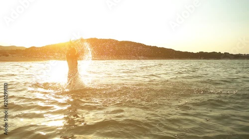 Little beautiful girl plays in warm summer sea