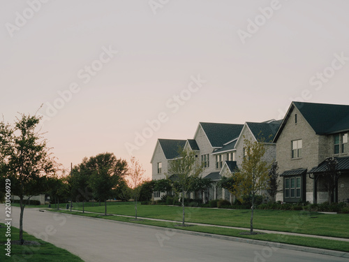 Quiet suburban residential street with brick houses at sunset