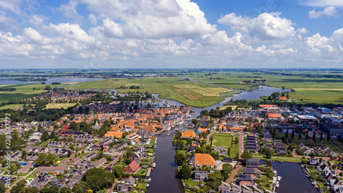Aerial view of a historic waterside village with boats and windmill in Europe