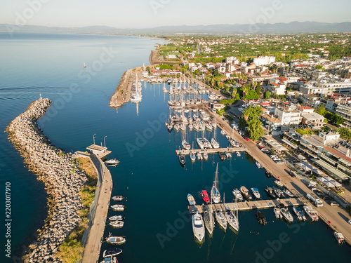 Aerial View of Kalamata Marina and Coastal Beaches in Morning Light, Greece. Beautiful morning sunlight creates striking contrasts across the marina, urban landscape and Mediterranean coastline