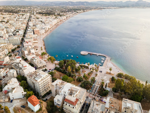 Aerial View of Loutraki Beach and Waterfront at Sunset, Gulf of Corinth, Peloponnese,  Greece showing the long beachfront stretching along the town from the beach park and waterfront promenade toward 