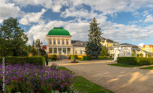 Historic Social Hall building with green dome and park gardens with flowers on a sunny summer day, Frantiskovy Lazne, Czech Republic