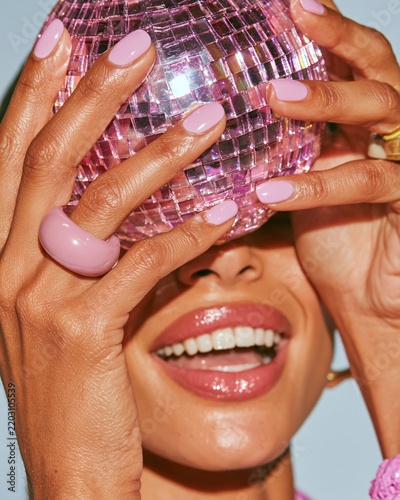 Close-up view of hands gripping a shiny disco ball for a Halloween celebration