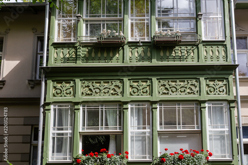 Old windows of green wooden veranda in historic building