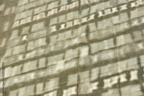 Intricate geometric shadows and sunlight on stone wall texture