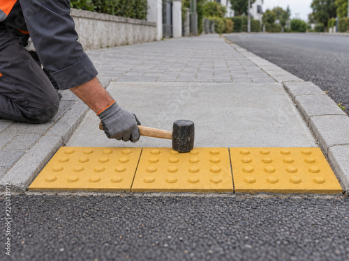 Municipal Worker Installing Tactile Paving at Accessible Curb Ramp