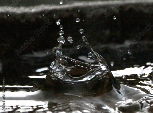 Closeup of a Raindrop Striking Water with Recoil