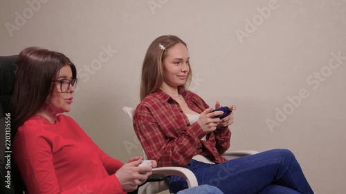 Women play games. Relaxed friends enjoying video games with cheerful interactions. Two women engage in friendly game night amid comfortable surroundings and joyful laughter