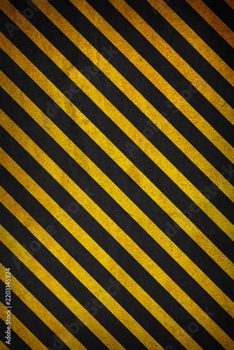 Industrial black and yellow striped grunge background with distressed texture. Abstract hazard stripe pattern. Suitable for warning themed graphics, construction projects, posters, banners, web design