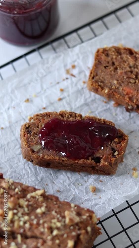 Hand is spreading homemade jam on a slice of bread. Vertical video.