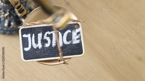 Handwritten word justice on a rustic balance scale.