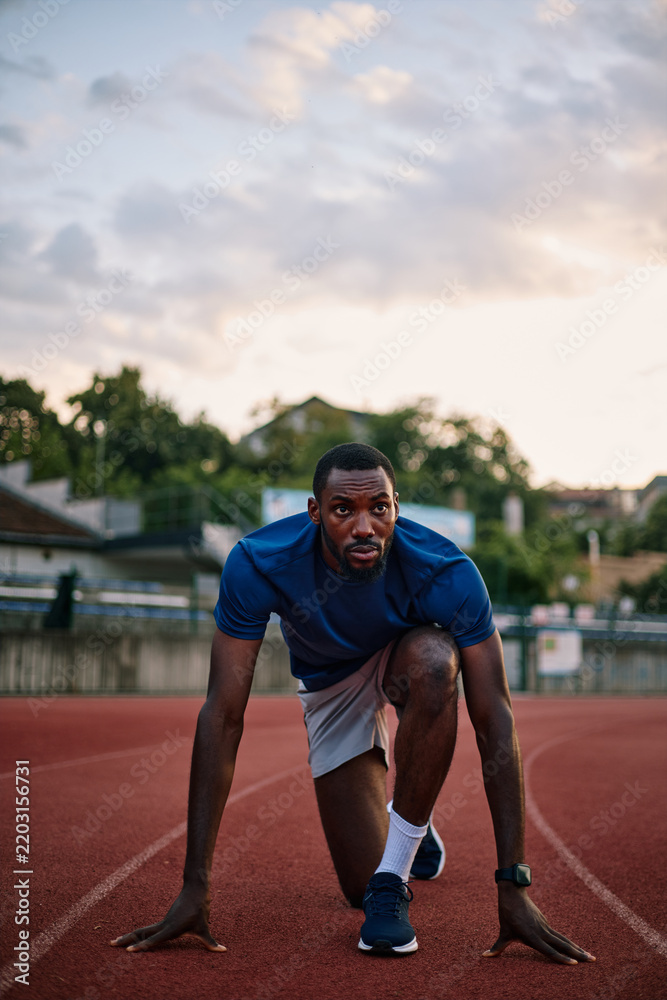 Obraz premium Determined athlete preparing for a sprint race on track