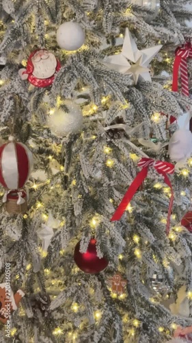 Red and white ornaments on a lit Christmas tree