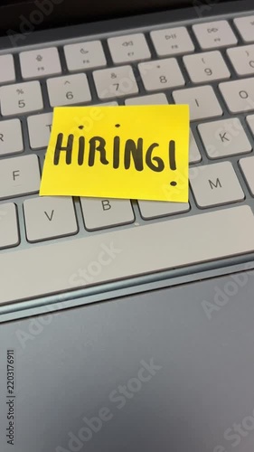 Hiring sticky note on laptop keyboard tech recruitment