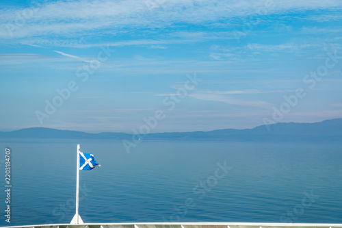 Quadro su tela Drapeau écossais flottant à la proue d'un ferry entre Kennacraig et Port Askaig,