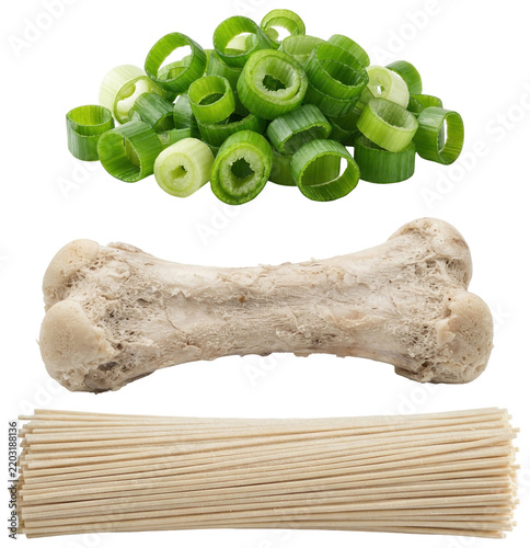 A collection of essential tonkotsu ramen ingredients including springy noodles, a pork bone and fresh scallions.