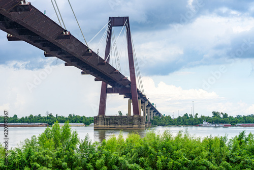 Wide View of the Hale Boggs Bridge over the Mississippi River with Tugboat and Barges Blurred in the Background