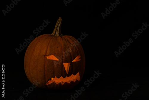 Carved pumpkin with spooky face for Halloween celebration in autumn