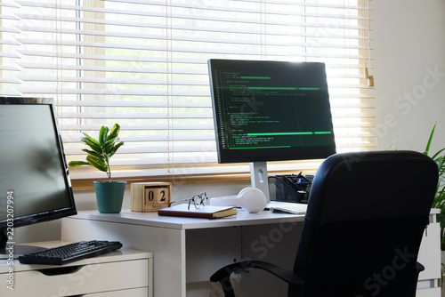 Programmers workplace with computer near window in office