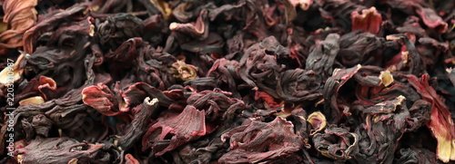 Dry egyptian hibiscus tea in big pile on table close up. Large amount of hibiscus tea leaves