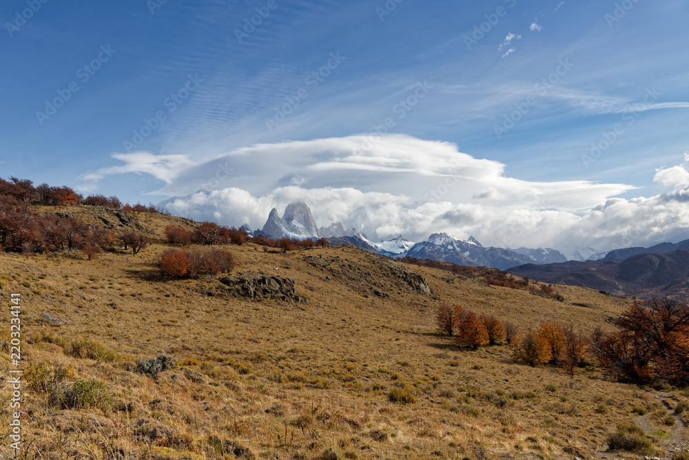 Obraz premium Spectacular lenticular cloud hovering above Mount Fitz Roy and the golden autumn steppe in Los Glaciares National Park, Patagonia, Argentina.