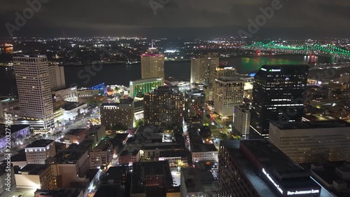 High-angle view of downtown New Orleans illuminated at night with modern skyscrapers and commercial buildings. Vibrant Louisiana skyline showcases contemporary urban architecture.