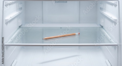 Single Wooden Pencil Lying on Clean Empty Refrigerator Glass Shelf