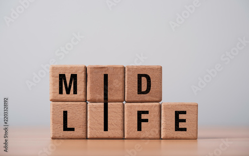 Midlife concept with wooden letter blocks forming MID LIFE, symbolizing middle age, life transition, personal change, aging reflection, new priorities, identity and a fresh stage of adulthood.